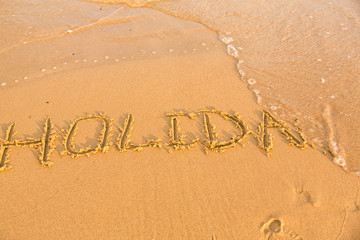 Fototapeta premium Word holiday on the yellow sandy beach