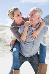 Laughing couple smiling at each other on the beach