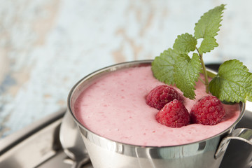 Cocktail of frozen raspberries with yogurt in a metal cup.