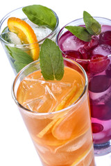 iced drinks with cherry, orange and mint on white background