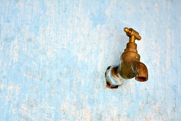 Old faucet in faded wall