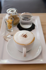 Cappuccino coffee cup with sugar, biscuit  and drinking water