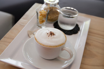 Cappuccino coffee cup with sugar, biscuit  and drinking water