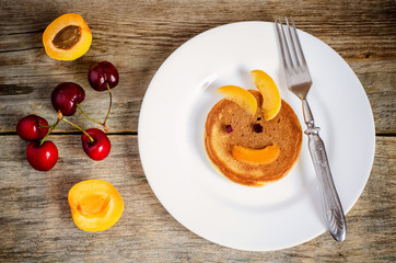 breakfast with fresh pancakes with cherries and apricots for kid