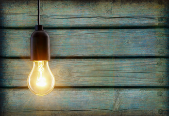 Light bulb lamp on wooden background with copy space