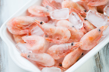 Glass bowl with iced shrimps, high angle view, close-up