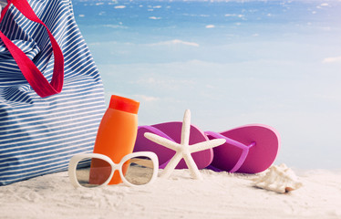 beach bag and flip-flops, sunglasses and starfish on the beach