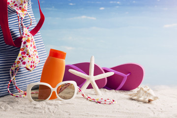 beach bag and flip-flops, sunglasses and starfish on the beach