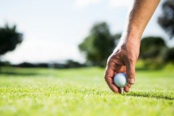 Golfer placing golf ball on tee