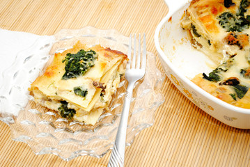 Eating Spinach Lasagna Served on a Glass Plate
