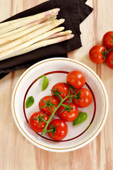 Cherry tomatoes with asparagus and basil leaves