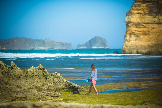 Woman Walks Alone on a Deserted Beach