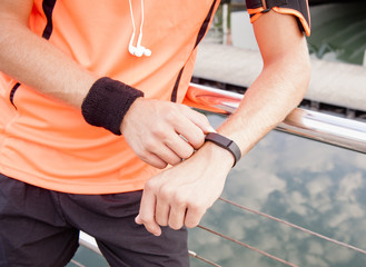 Young runner leaning against railing with exercise gear