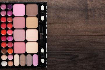make-up palette on brown wooden background