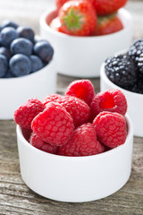 fresh raspberries in a bowl and berries, closeup