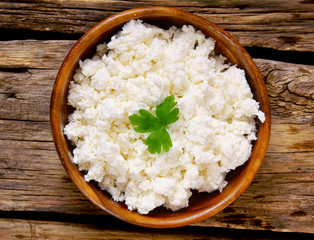 Cottage cheese on wooden board .