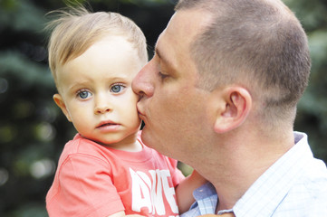 Dad kissing his son