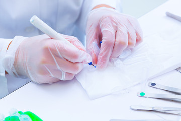 laboratory assistant signs tubes with the results of medical ana
