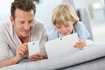 Father and son playing with tablet and smartphone