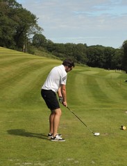 A golfer ready to hit the golfball down the fairway