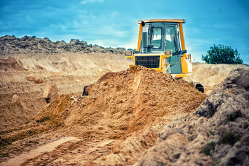 industrial bulldozer and excavator working with earth in sandpit