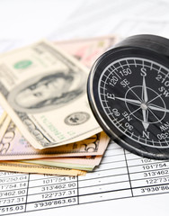 Compass and money (dollars) on documents.