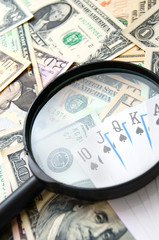 Magnifier and game cards on banknotes.