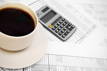 Cup from coffee, the calculator on documents.