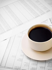 Cup of coffee on documents.