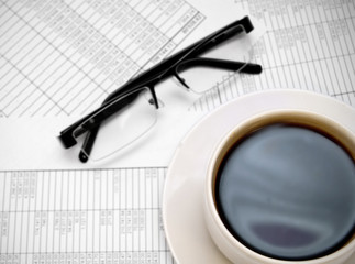 Glasses and a cup of coffee on documents.