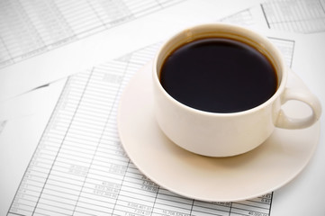 Cup from coffee on documents.