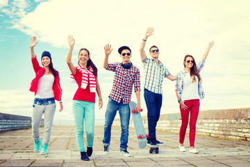 Obraz premium group of smiling teenagers waving hands