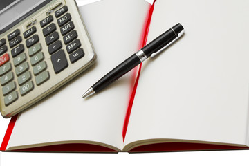 Calculator and pen on blank notebook. Shot on white background