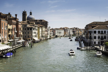 Ancient buildings and boats in the channel in Venice