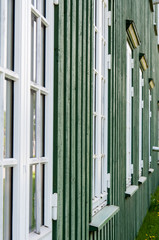 Obraz premium White wooden windows and green walls in Norway