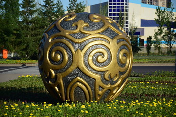 A decorative sphere on a flowerbed