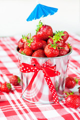 Generous crop of ripe fresh juicy gourmet strawberry in bucket