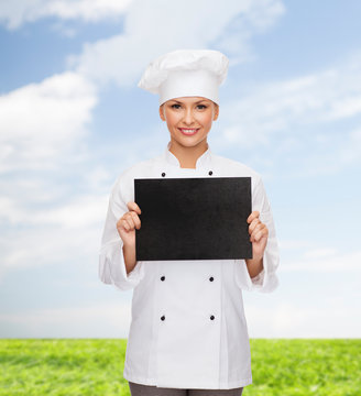 smiling female chef with black blank paper