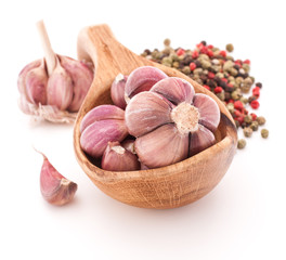 Garlic cloves in wooden bowl isolated on white background
