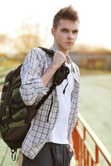 Outdoor lifestyle portrait of handsome guy with backpack