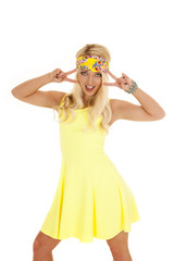 woman yellow dress headband stand two peace signs