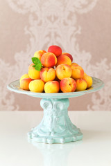 Ripe fresh apricots in a vase on table, selective focus