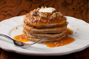 Top view of wholesome whole wheat homemade pancakes topped with walnuts and apricot sauce