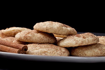 Plate full of cinnamon sugar Snickerdoodle cookies isolated on a black background