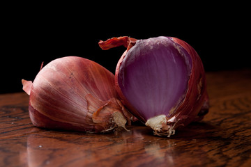 Close up of organic French Red Shallots on a black background