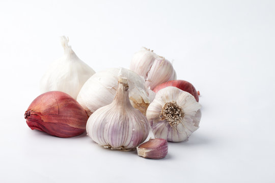 Studio shot of organic garlic and shallots assortment - Music Garlic, Spanish Roja Garlic, Russian Red Garlic, Elephant Garlic, California White Garlic, and French Red Shallots