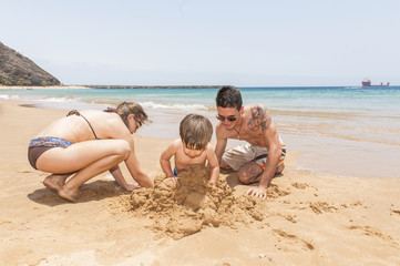 Happy family playing on the beach