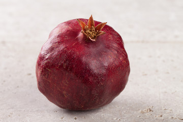 Freshly picked pomegranate isolated on a travertine tile