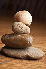 Fototapeta na wymiar Zen river rocks staked on a wooden table