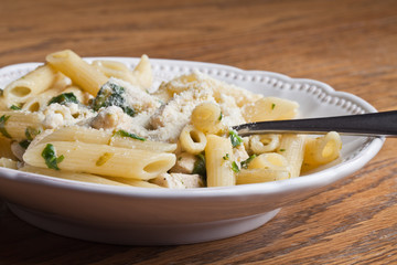 Chicken Penne pesto with spinach, asparagus, and Parmesan cheese